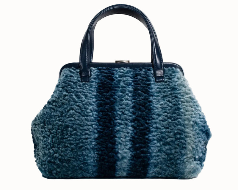 Blue textured handbag with black handle on a white background