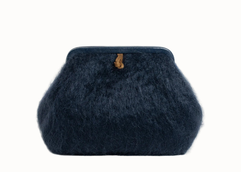Dark blue textured clutch bag with a brown tag on a white background